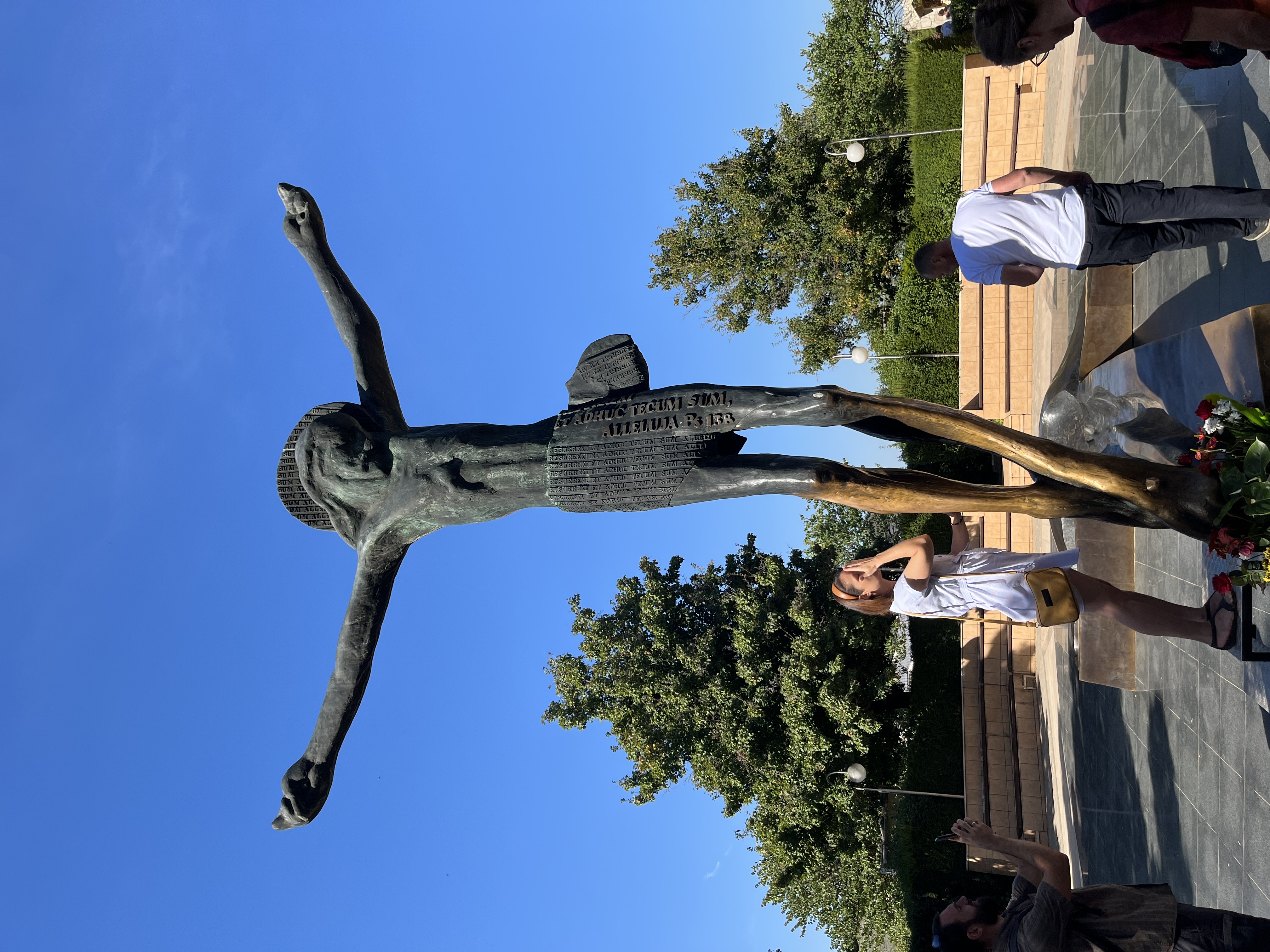 Bronze Risen Christ sculpture with visitors in Medjugorje, Bosnia and Herzegovina