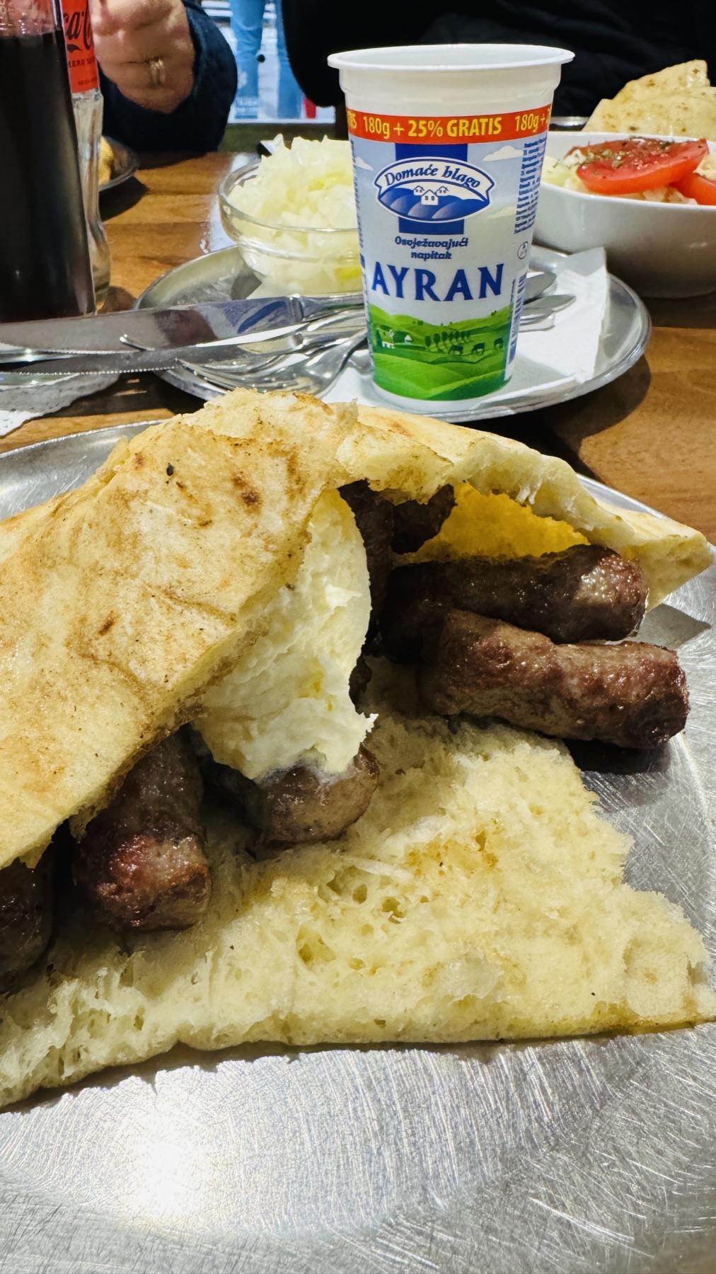Ćevapi in somun bread with onion and a cup of jogurt in Sarajevo