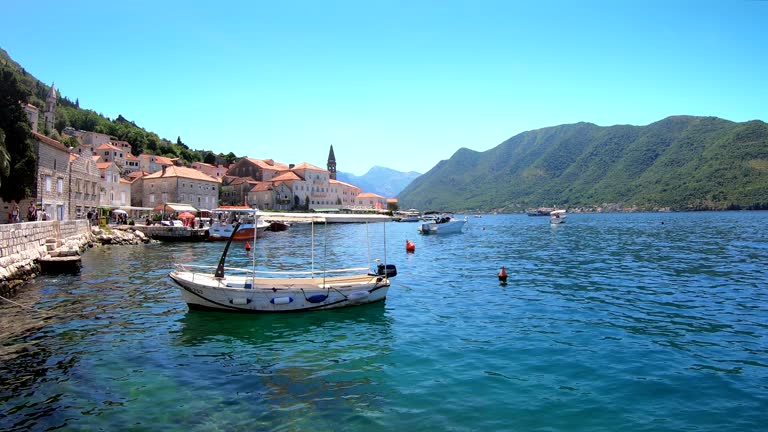 Small boats on the clear waterfront of Perast across the Bay of Kotor, Montenegro